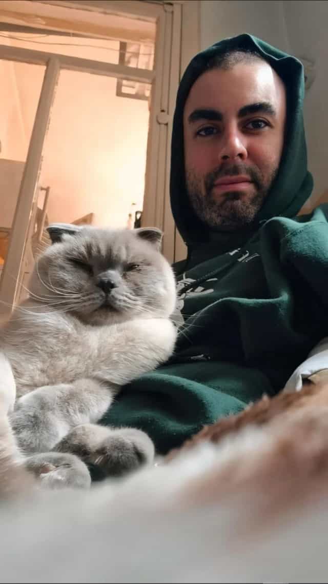 Lotus resting against a person wearing a green hoodie